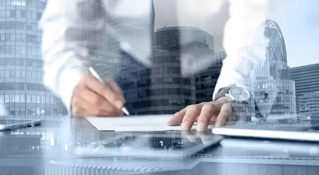 Profesional trabajando con documentos y tecnología, enfocado y preciso, reflejando la labor de un asesor fiscal en un entorno corporativo.