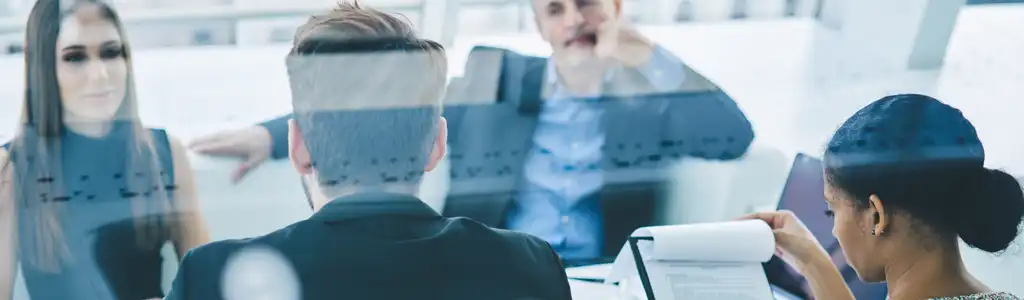 Reunión profesional con documentos y análisis en equipo, reflejando el trabajo de un asesor laboral en un entorno corporativo.